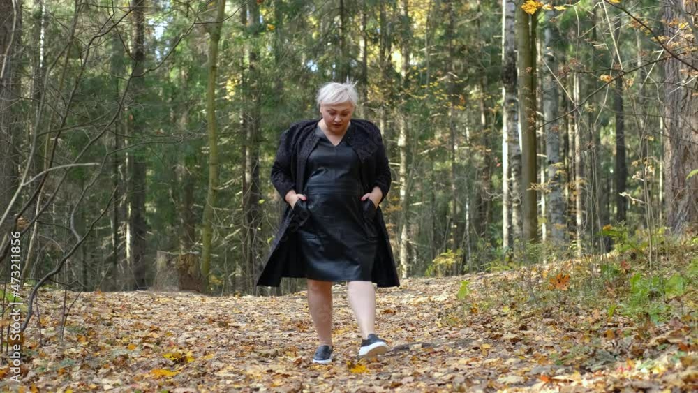 stylish woman xxl size walks in the autumn park stylish woman xxl size walks in the autumn park