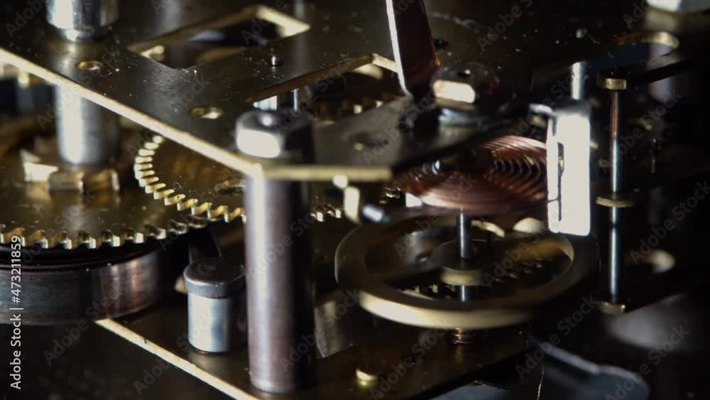 Macro video of the primitive clockwork mechanism of an old desktop alarm clock
