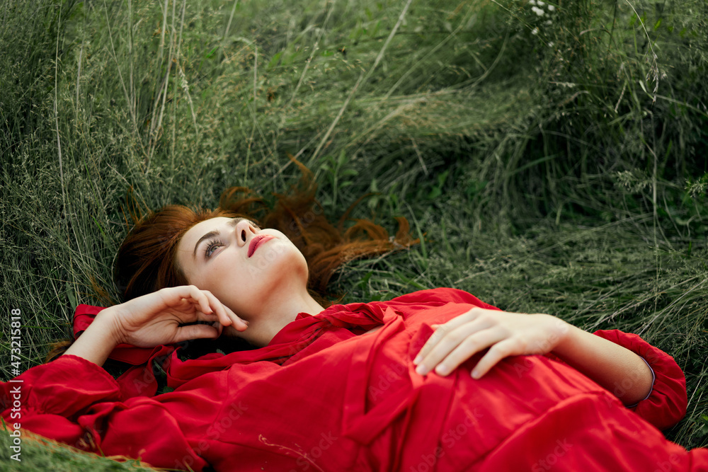 pretty woman in red dress lies on the grass freedom landscape pretty woman in red dress lies on the grass freedom landscape