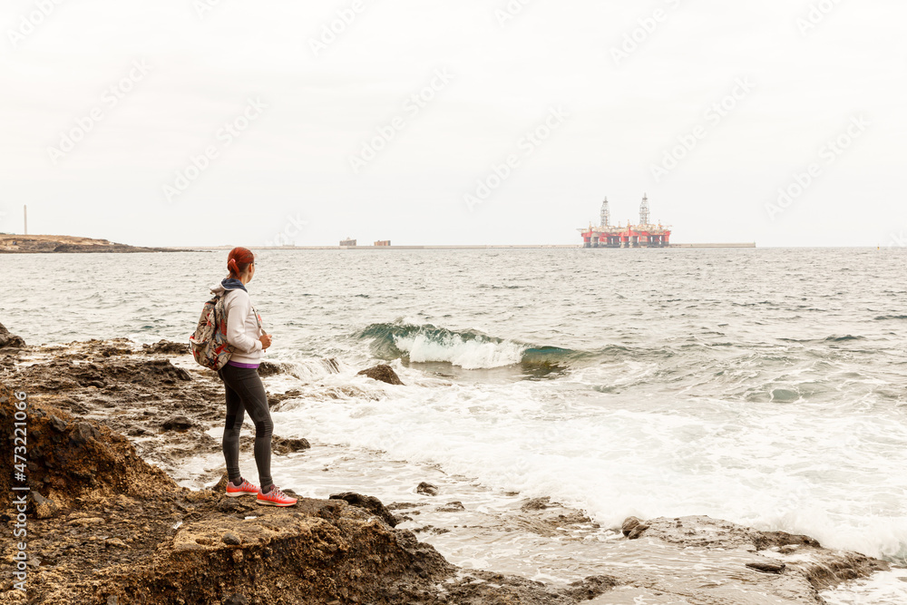 Girl looking at oil rigs