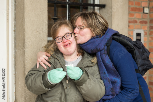 Tienen, Flanders  Belgium - 07 20 2018: Portrait of a young white woman kissing a woman with Down Syndrome. photo