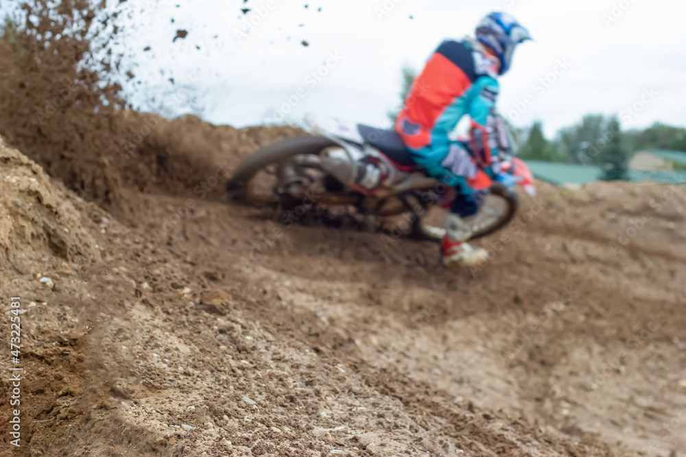 Blurred silhouette, motorcycle racer enters turn on racing dirt track, earth is flying around. Concept of extreme. Blurred silhouette, motorcycle racer enters turn on racing dirt track, earth is flying around. Concept of extreme.