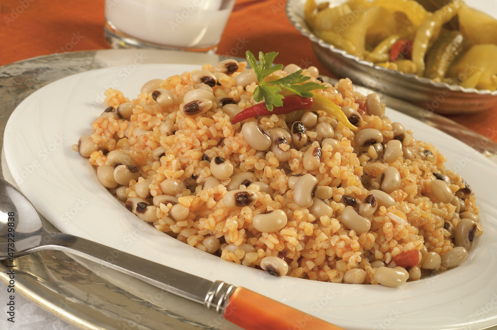 Bulgur pilavi with tomatoes and dry cowpea concept background