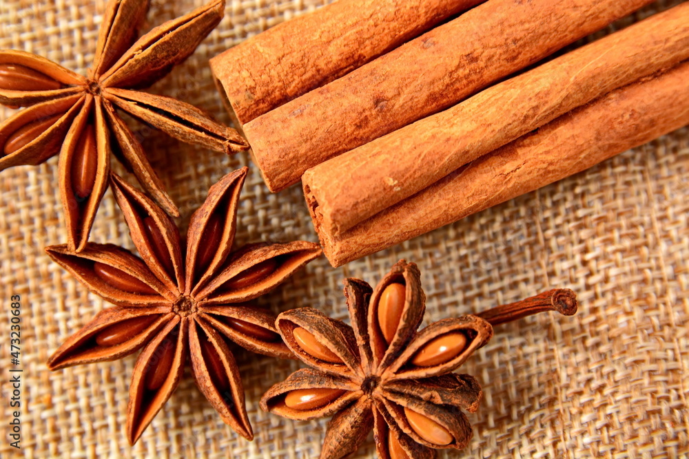 heap of star anise and group sticks of cinnamon close up on canvas fabric heap of star anise and group sticks of cinnamon close up on canvas fabric
