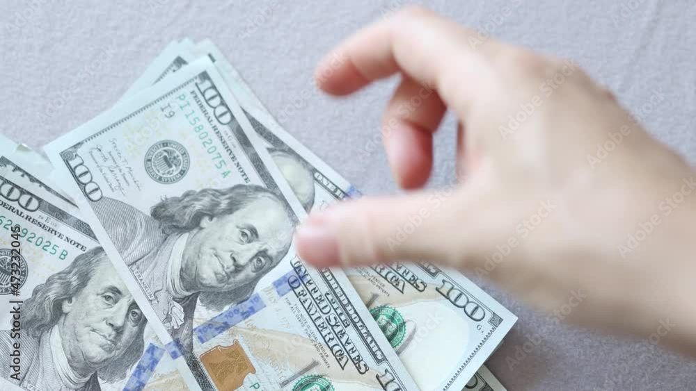 hand recounting hundred dollar banknotes American money bills falling on grey background hand recounting hundred dollar banknotes American money bills falling on grey background