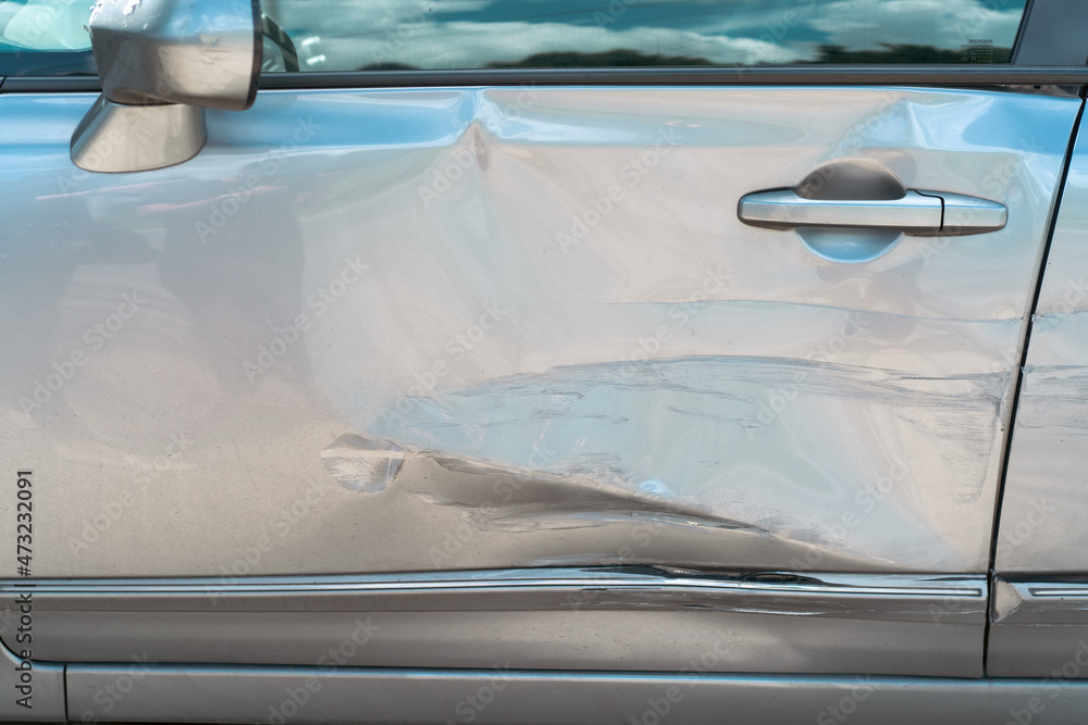 Side view of damaged vehicle parking on the road close up. Careless driving cause of car accident. Side view of damaged vehicle parking on the road close up. Careless driving cause of car accident.