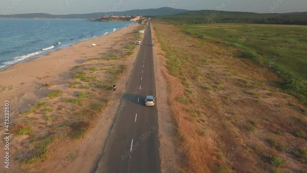 Drone Following A Car Driving On Coastal Road On A Sunny Afternoon. aerial Drone Following A Car Driving On Coastal Road On A Sunny Afternoon. aerial