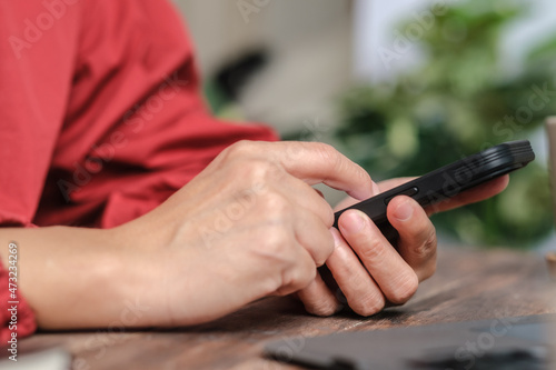 close up woman hand using credit card shopping online on mobile app on wood table at home