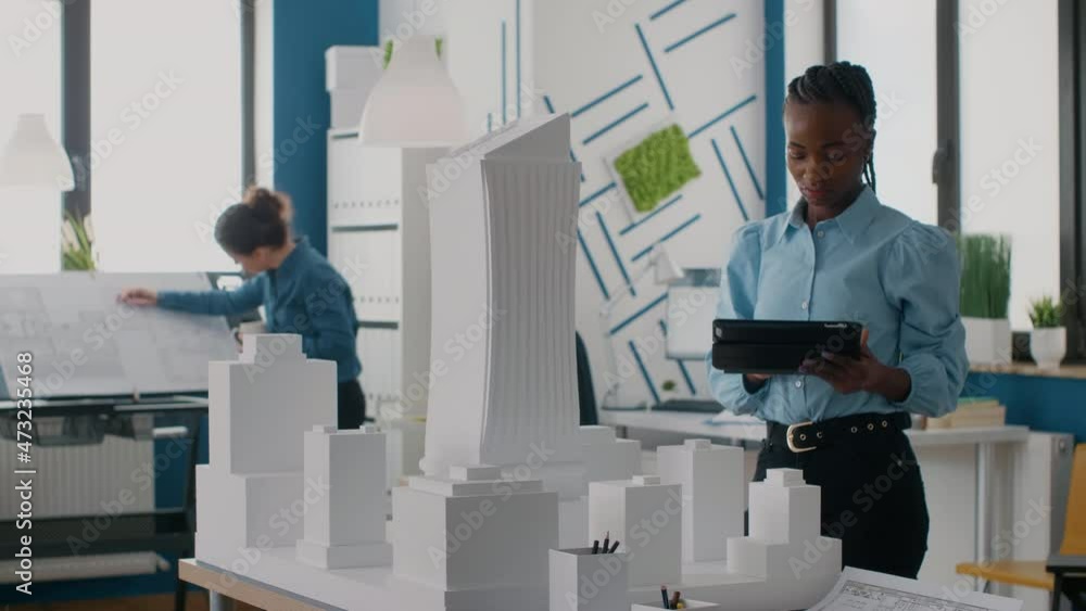 African american engineer holding tablet to work on building model and ...
