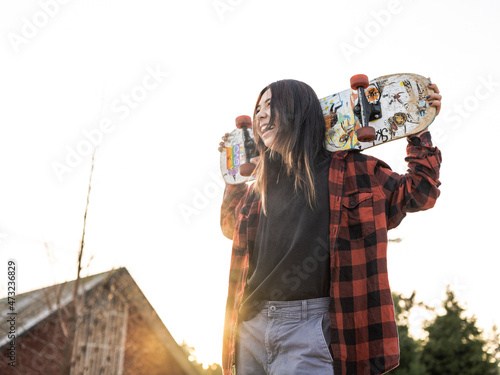 Young Indigenous non-binary skater outdoors photo