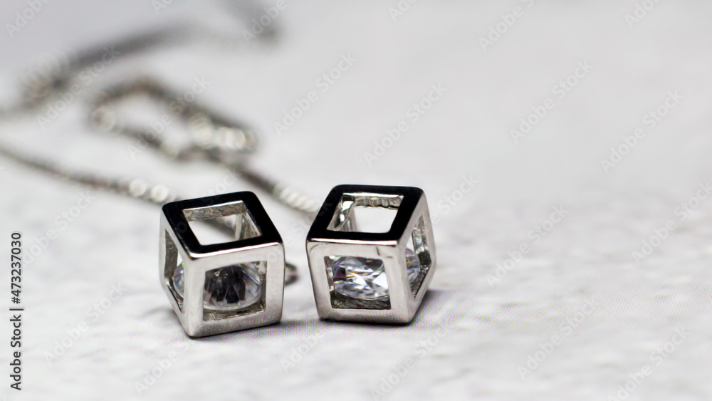 Silver earrings with cubic diamonds, gray background Silver earrings with cubic diamonds, gray background