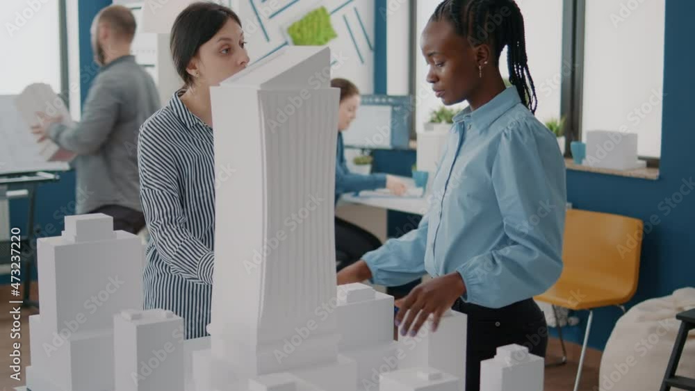 Architects working with building model to plan construction layout ...
