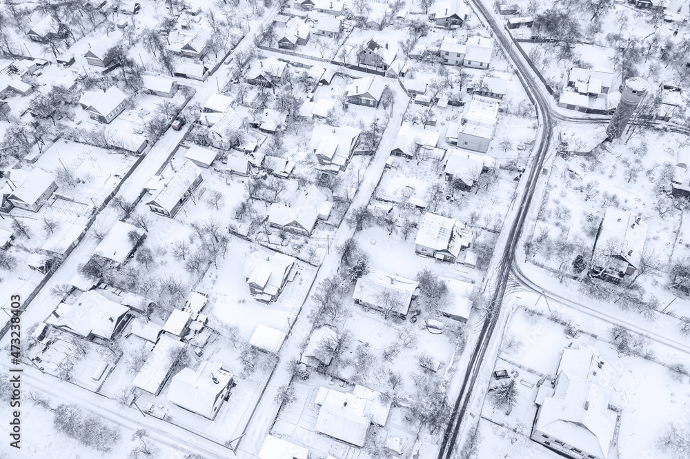 winter village with snow-covered houses and roads. aerial view from flying drone. winter village with snow-covered houses and roads. aerial view from flying drone.