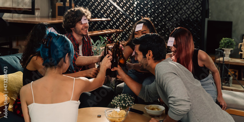 фотографія Diverse group of young people partying and toasting a drink in the house enjoying nightlife
