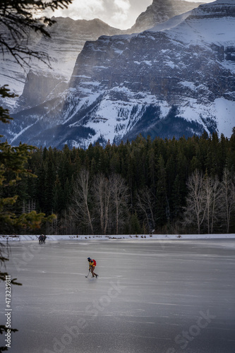 An Ice Hockey player skating of a frozen mountain lake in the Canadian Rockies near Banff. © Ramon Cliff