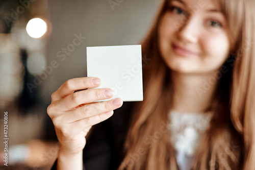 Business Woman hand holding square blank clean sticker mock up. Close up background place for text