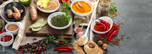 Assortment of spices on gray background.