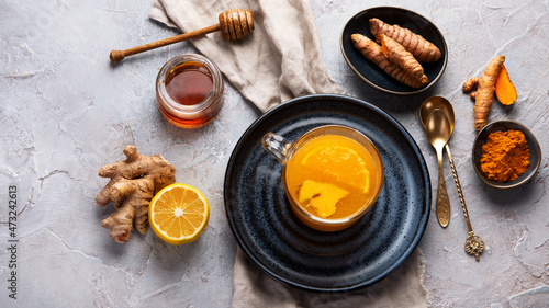 Healthy turmeric golden tea on light gray background.