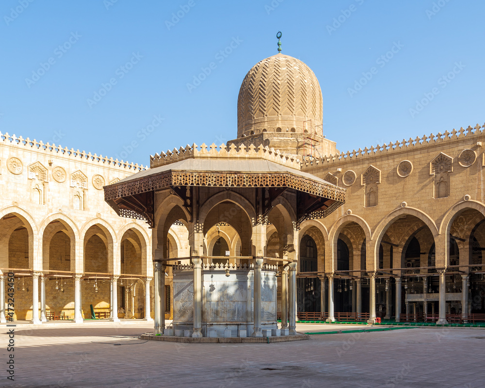 Ablution fountain mediating the courtyard of public historic mosque of Sultan al Muayyad, with background of arched corridors surrounding the courtyard, and dome of the mosque, Cairo, Egypt