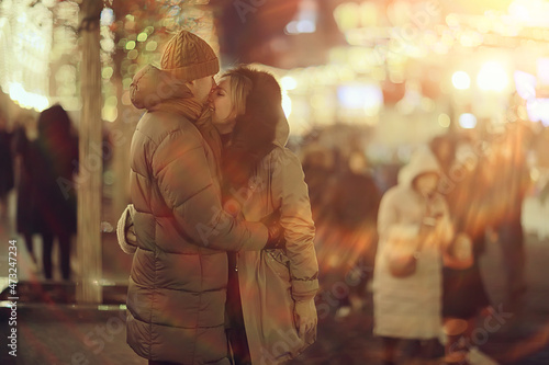 couple in love on a christmas walk in the city  evening snowfall december holiday new year
