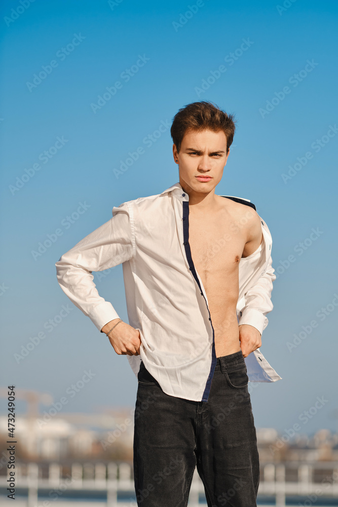 Young man in unfastened shirt on the street Young man in unfastened shirt on the street
