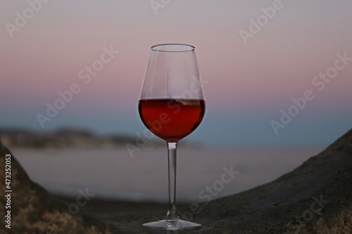glass of red wine on the beach