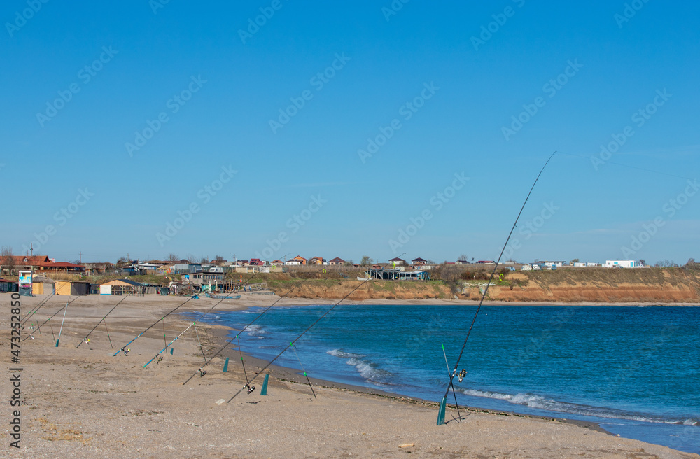 landscape with many rods placed for fishing on the beach landscape with many rods placed for fishing on the beach