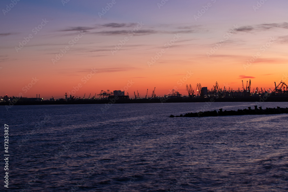 landscape with the silhouettes of cranes from the port of Constanta in the evening