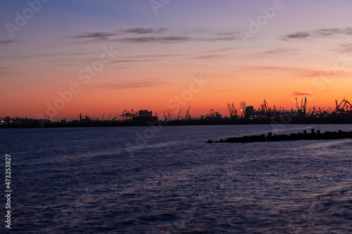 landscape with the silhouettes of cranes from the port of Constanta in the evening © sebi_2569