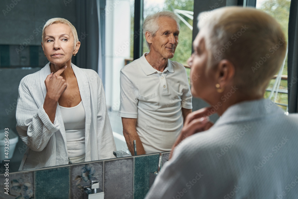 Fototapeta premium Cute senior woman looking at her reflection