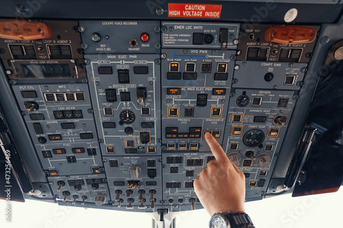 Finger of aircraft pilot turning on windshield heating photo