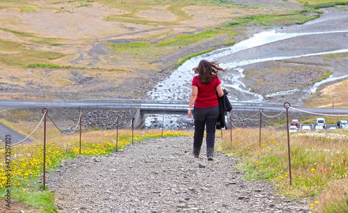 Woman holding a traditional Icelandic sweater, enjoying the Icelandic landscape photo