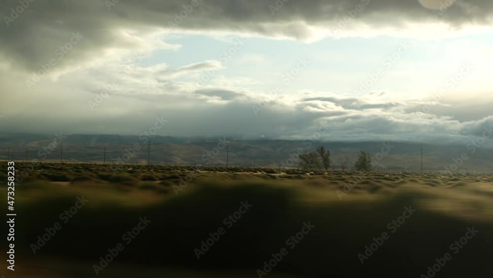 Driving auto, road trip in California, USA, view from car. Hitchhiking traveling in United States. Highway, mountains and cloudy dramatic sky before rain storm. American scenic byway. Passenger POV. Driving auto, road trip in California, USA, view from car. Hitchhiking traveling in United States. Highway, mountains and cloudy dramatic sky before rain storm. American scenic byway. Passenger POV.