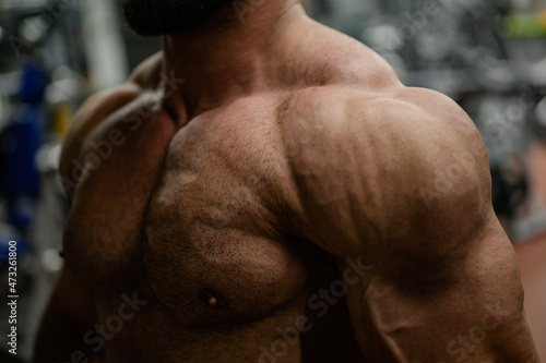 strong athlete powerful bodybuilding man shoulder and chest with arm body part in sport gym