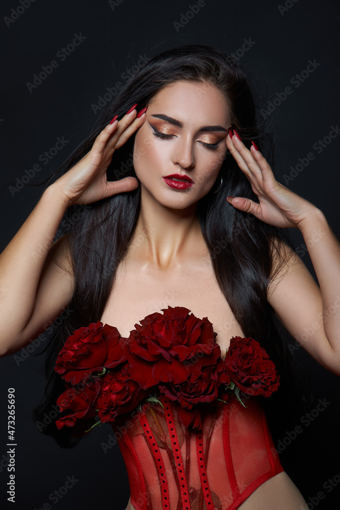 Beautiful brunette woman with a bouquet of red rose flowers in red corset. Long hair, nude slim body art portrait Beautiful brunette woman with a bouquet of red rose flowers in red corset. Long hair, nude slim body art portrait