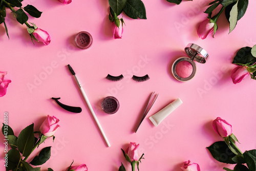 Canvas Print Fake eyelashes, tweezers, eyeshadows and lashes glue on pastel pink background with rose flowers