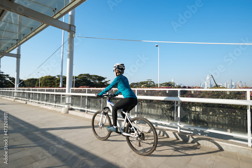 Woman riding bike at city on sunny day