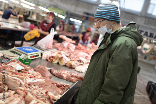 Adult man buying fresh meat at market. Food shopping concept.