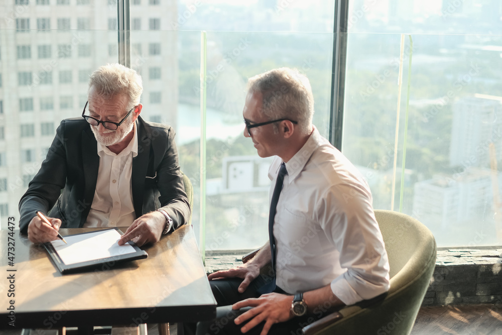 Two Senior businessman couple meeting in co working space at office Two Senior businessman couple meeting in co working space at office