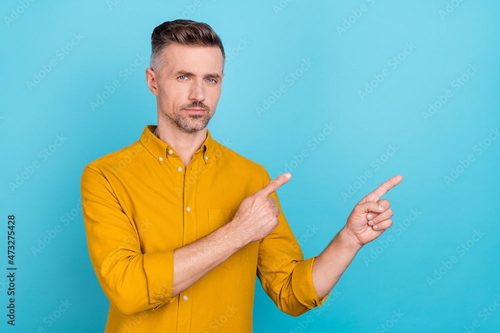 Photo of mature guy point index finger empty space direct adverts promo isolated over sky light color background Photo of mature guy point index finger empty space direct adverts promo isolated over sky light color background