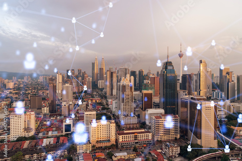 Photography Hologram of social media icons over sunset panoramic cityscape of Kuala Lumpur, Malaysia, Asia