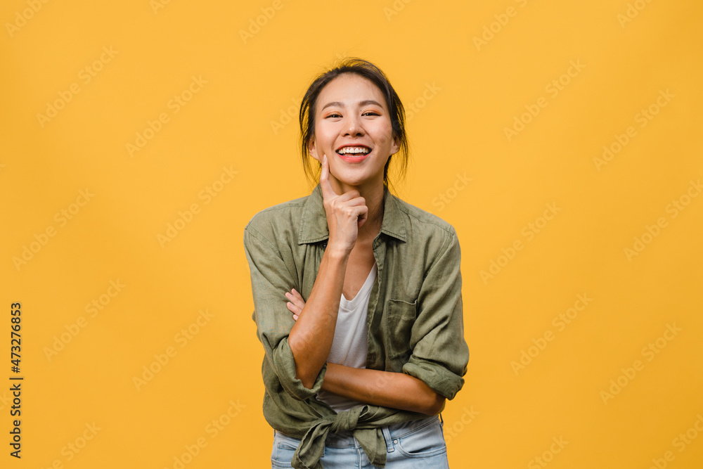Portrait of young Asia lady with positive expression, arms crossed, smile broadly, dressed in casual clothing and looking at camera over yellow background. Happy adorable glad woman rejoices success. Portrait of young Asia lady with positive expression, arms crossed, smile broadly, dressed in casual clothing and looking at camera over yellow background. Happy adorable glad woman rejoices success.