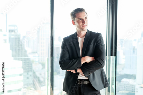 business caucasian man standing in office room near window