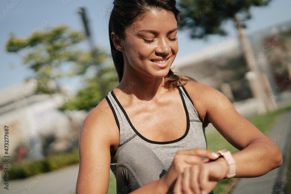 Beautiful athlete woman in sportswear outdoors. Young woman resting after training Beautiful athlete woman in sportswear outdoors. Young woman resting after training