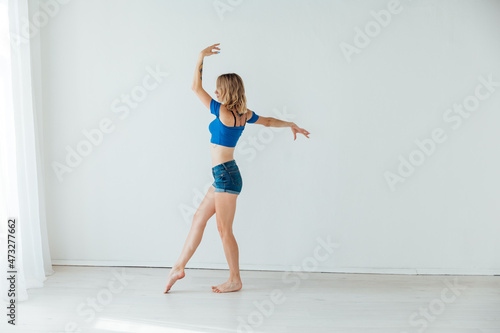 Fototapeta Naklejka Na Ścianę i Meble -  beautiful athletic blonde woman dancing to music alone