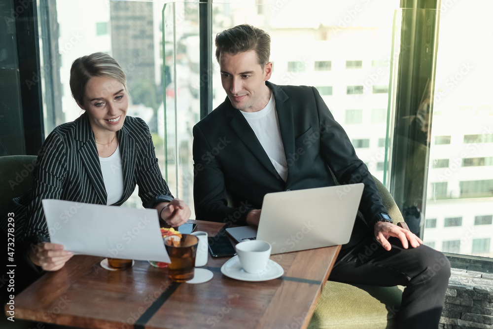 Two businessman and businesswoman couple meeting in co working space or office Two businessman and businesswoman couple meeting in co working space or office