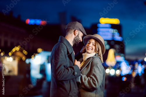 Affectionate couple flirting outdoors on Valentine's day. A young happy couple standing on the street at night and flirting on Valentine's day. © dusanpetkovic1