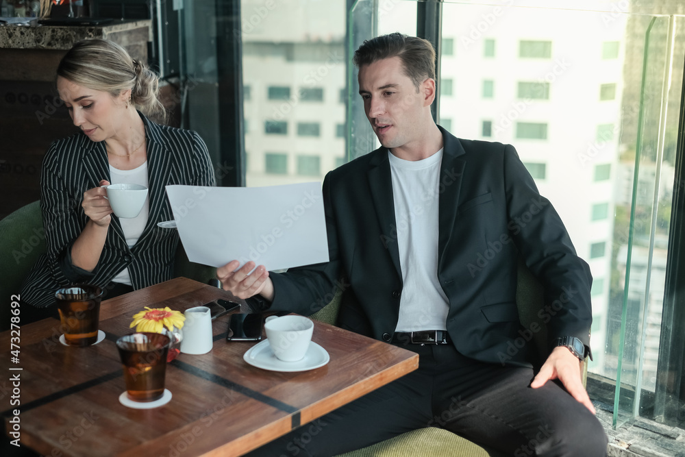Two businessman and businesswoman couple meeting in co working space or office Two businessman and businesswoman couple meeting in co working space or office