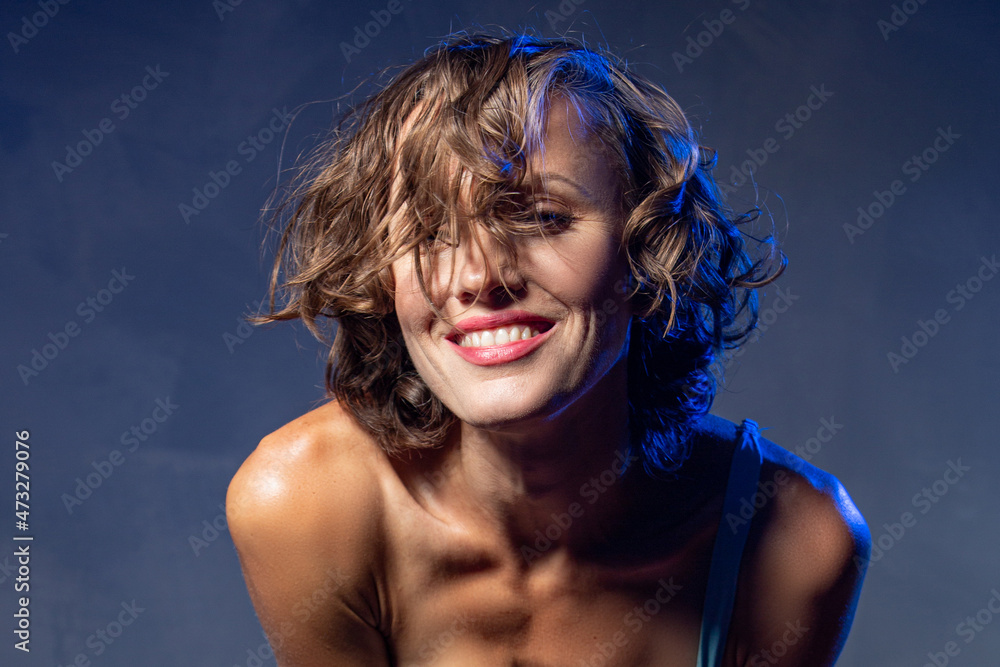 Naklejka premium Sexy young woman portrait. Seductive young woman with long hair posing in spotlight. Wide angle