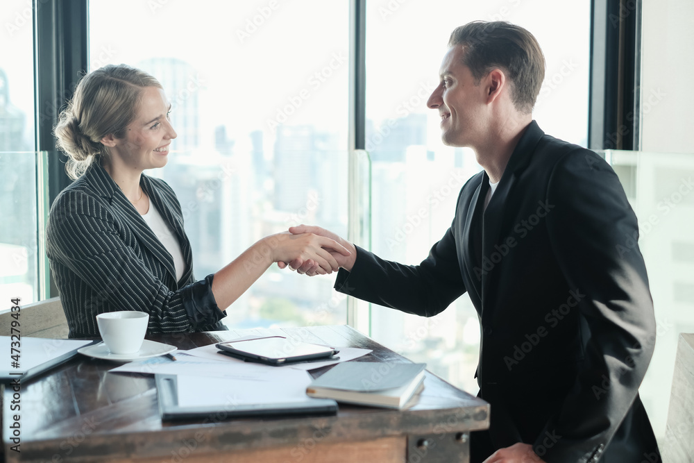 Two businessman and businesswoman couple meeting in co working space or office Two businessman and businesswoman couple meeting in co working space or office
